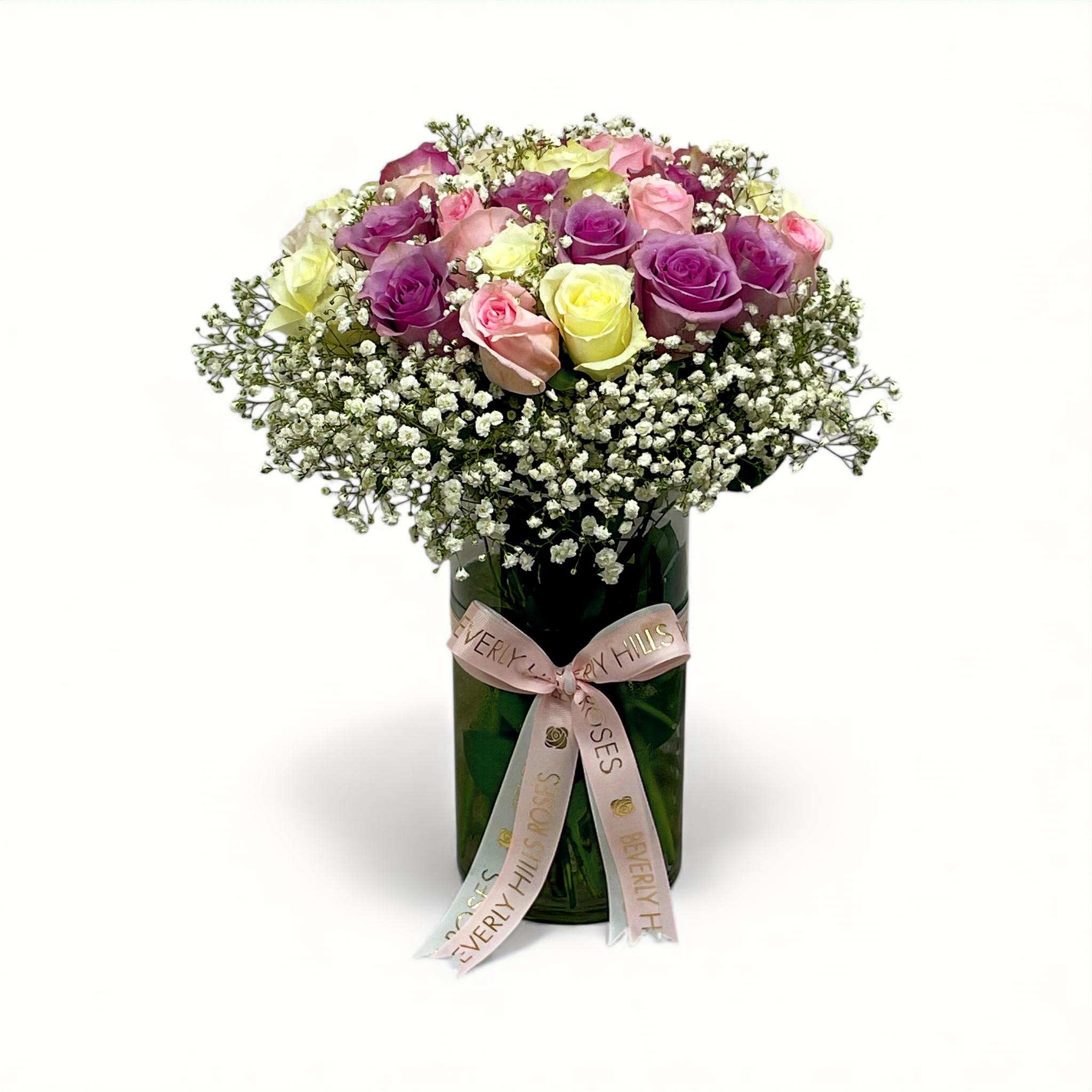 Light purple, pink, and white roses surrounded by baby’s breath in a clear vase – Beverly Hills Roses Dubai