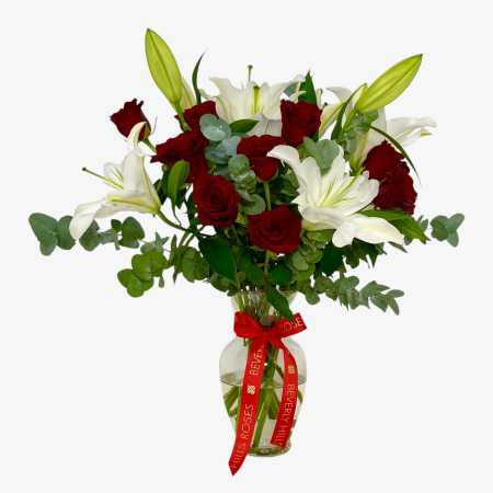 red roses and white lilies in a clear glass vase arrangement Dubai