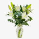 White lilies in a glass vase with eucalyptus and greenery in Dubai